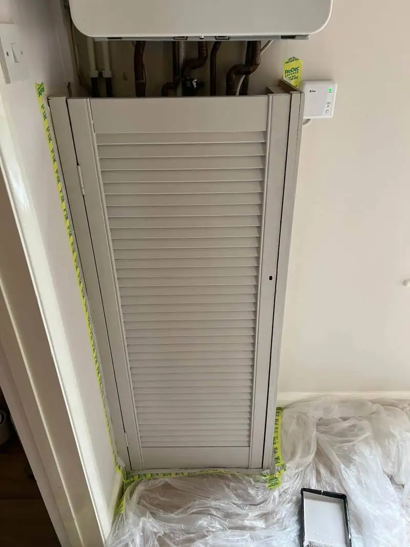 The same louvred cupboard door repainted in a pale neutral colour