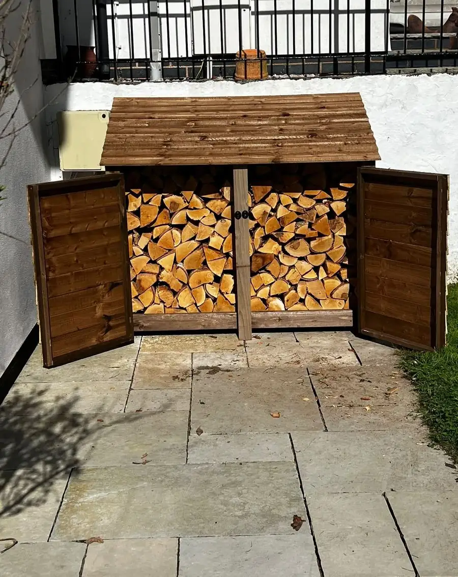 Finished timber log store with its doors open, stacked full of firewood