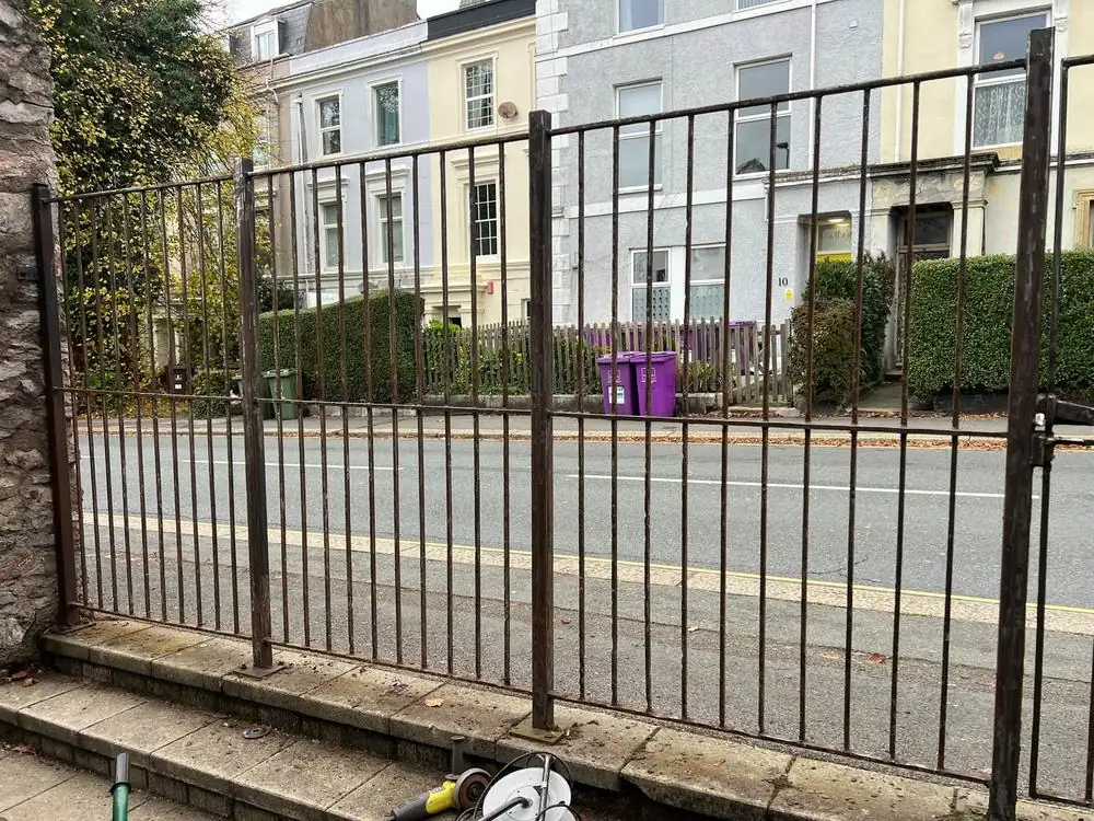 Rusted metal railings and posts before being sanded and repainted
