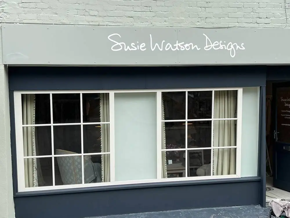 The shopfront after repainting, with dark blue woodwork and cream window frames