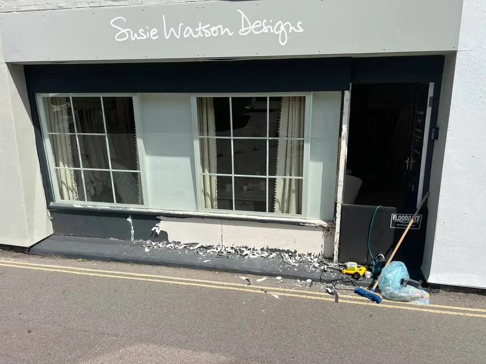 Shopfront with old paint being stripped from the panel below the window