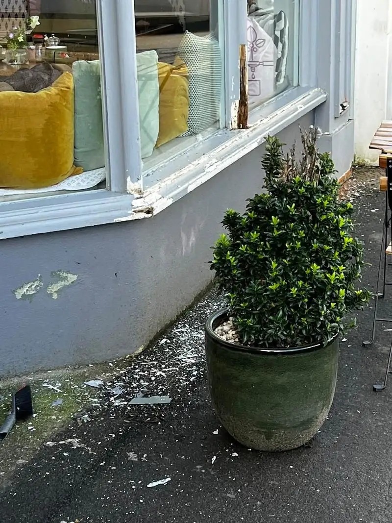 Shopfront window sill before the work, with rotten timber and peeling paint